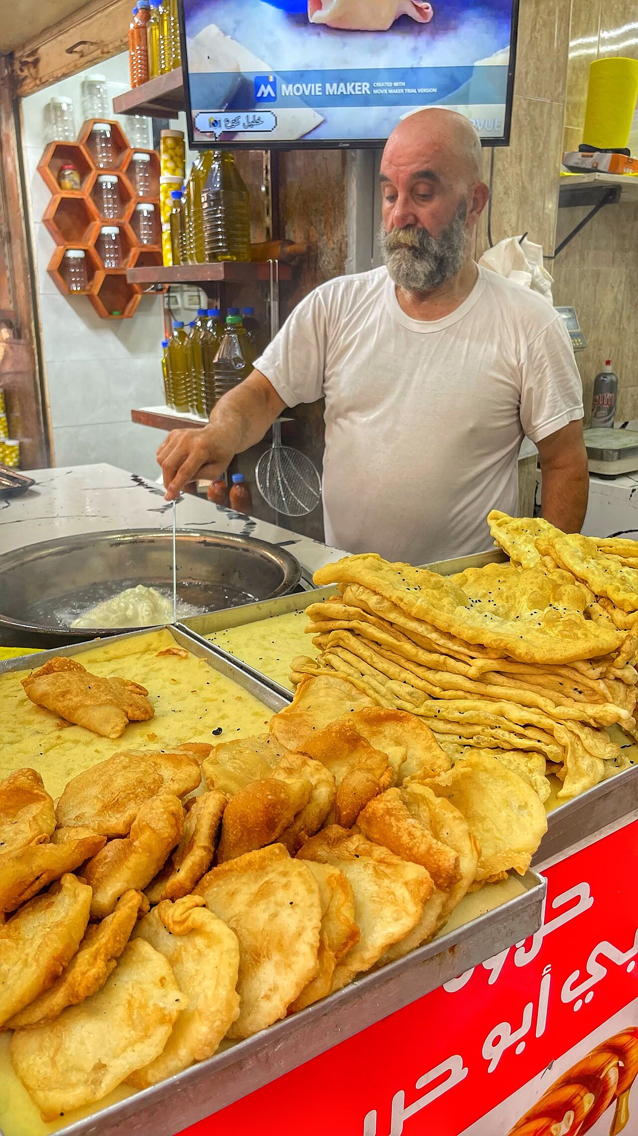 A street vendor in Nablus frying qatayef and stacking the finished pastries